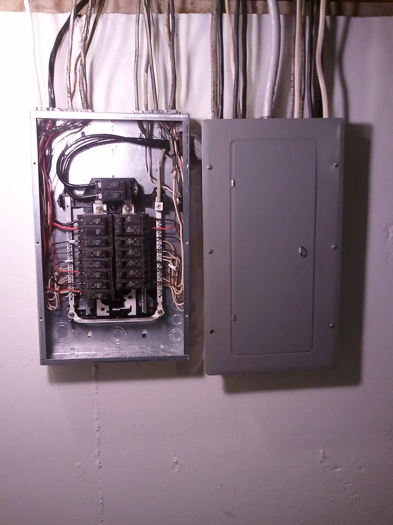 Residential subpanel with the cover removed, showing breakers and wiring